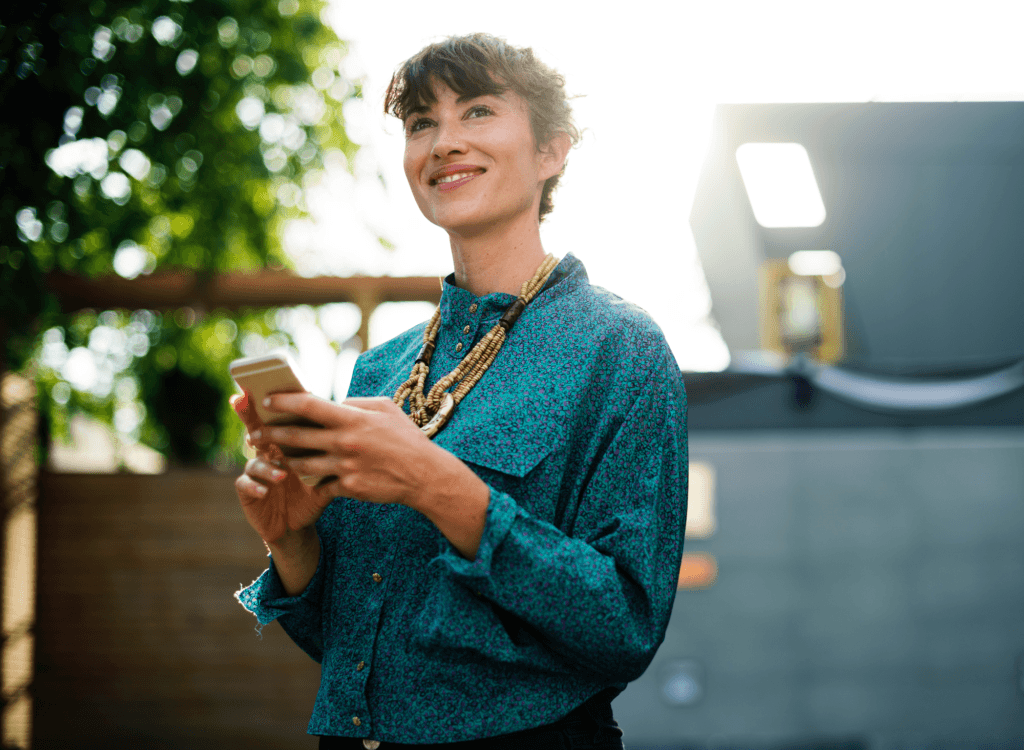 A woman in a blue button down shirt smiles thoughtfully wile she holds a cellphone. Small business owners are always hunting for cost-effective business solutions. Which helps explain why so many are turning to QuickBooks Online. QuickBooks Online cost-effective, but it allows for better efficiency and greater flexibility.