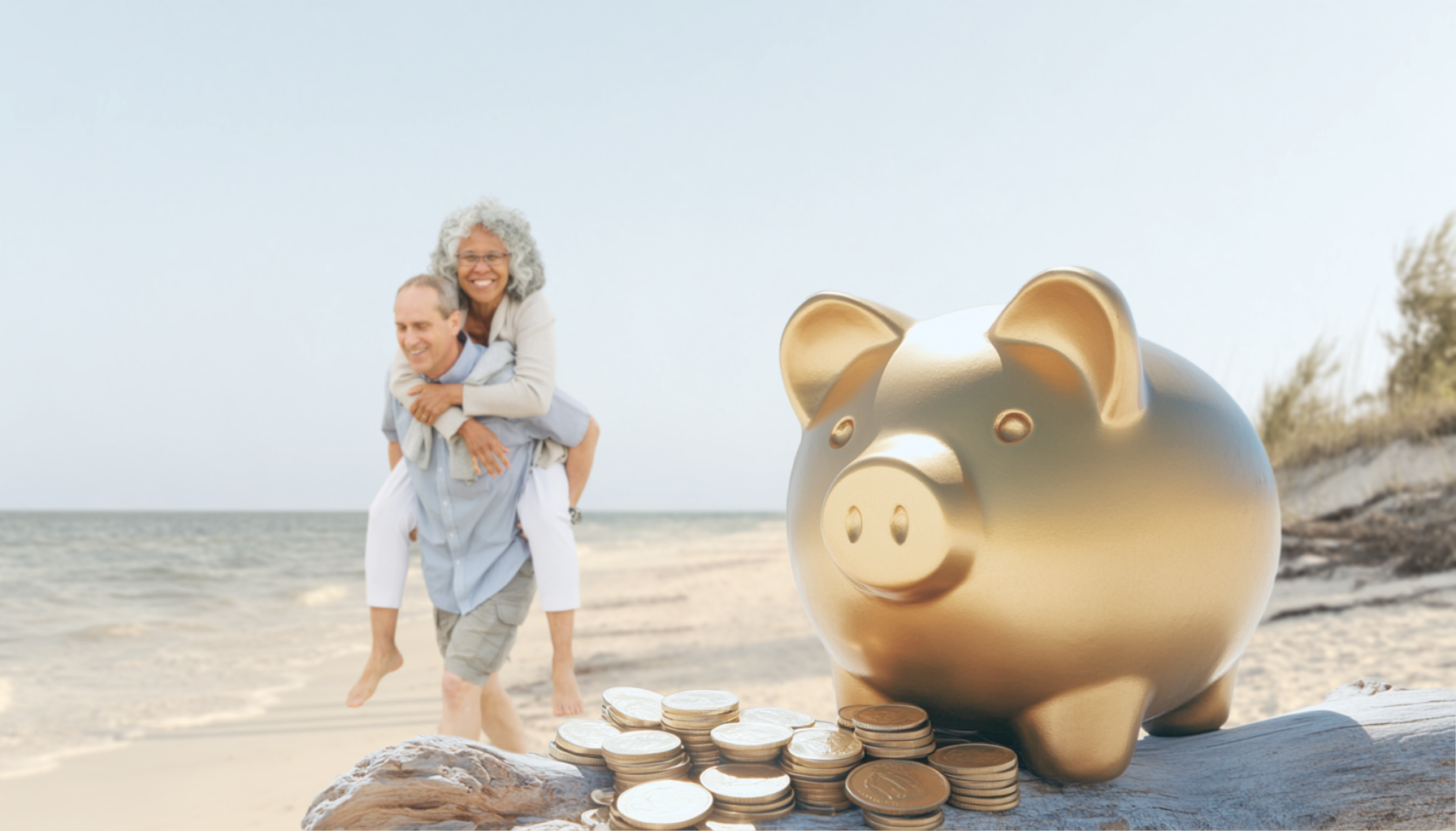 A couple in their mid-sixties frolics on a white sandy beach, while, in the foreground, a golden piggy bank and gold coins are situated on a piece of driftwood, representing retirement savings. The couple is carefree knowing they've saved for their later years.